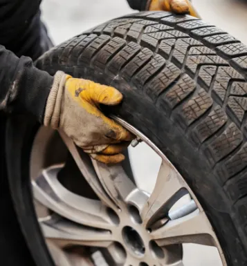 mechanic with gloves holding tire