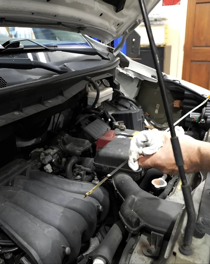 mechanic checking oil dip stick