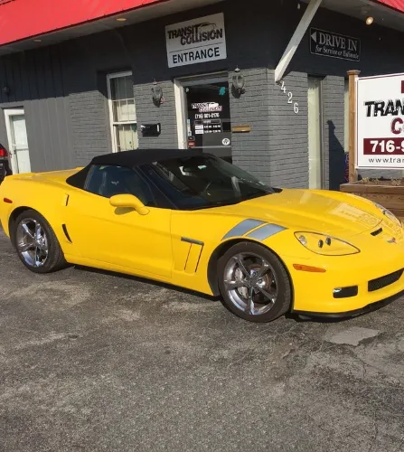 yellow corvette in front of auto shop